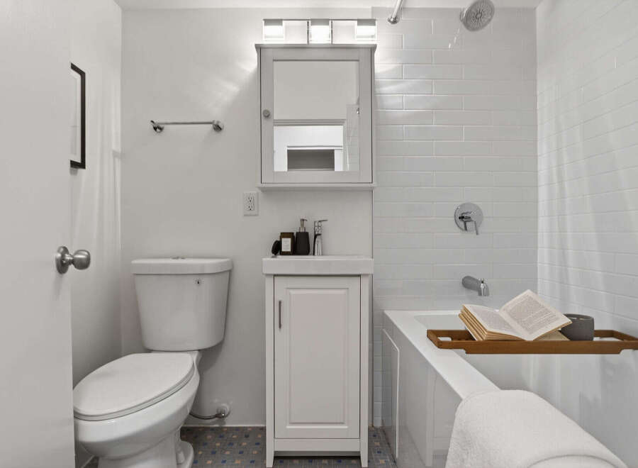 Step into this beautifully designed bathroom, featuring a modern vanity and a sleek, white color scheme.