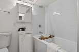 This modern bathroom features a sleek, minimalist design with bright white subway tiles and a clean, contemporary vanity.