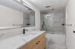 This modern bathroom features a sleek design with a marble countertop and a wooden vanity.