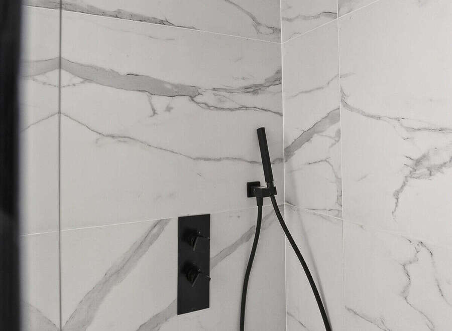 Step into luxury with this stunning bathroom featuring a sleek black showerhead and fixtures.
