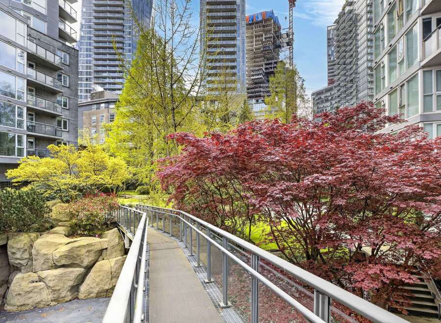 Discover urban living at its finest with this stunning property, featuring a serene bridge surrounded by vibrant red and yellow trees.