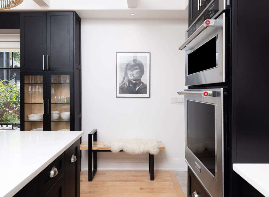 This modern kitchen boasts sleek black cabinetry, offering ample storage and a sophisticated aesthetic.