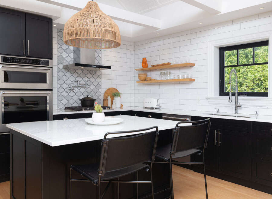 This stunning kitchen boasts modern design with sleek black cabinetry and a bright white countertop island, perfect for both cooking and entertaining.