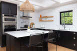 This stunning kitchen boasts modern design with sleek black cabinetry and a bright white countertop island, perfect for both cooking and entertaining.