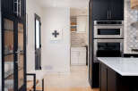 This stunning kitchen boasts modern design with sleek black cabinetry and stainless steel appliances.