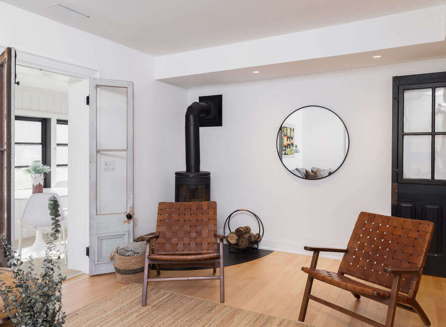 This stunning property boasts a cozy living space with a modern fireplace and stylish leather chairs, perfect for relaxing evenings.