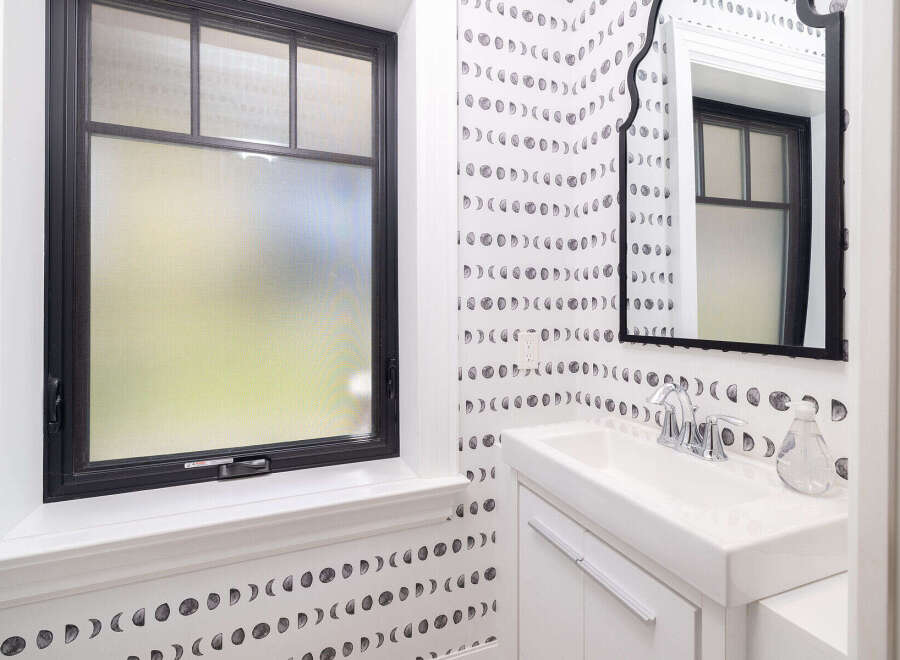 This stylish bathroom features a unique moon phase wallpaper, creating a serene and artistic atmosphere.