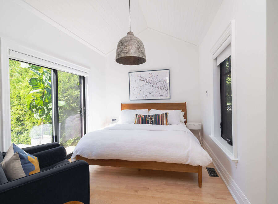 This stunning bedroom offers a serene retreat with its bright, airy design and natural light.