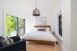 This stunning bedroom offers a serene retreat with its bright, airy design and natural light.