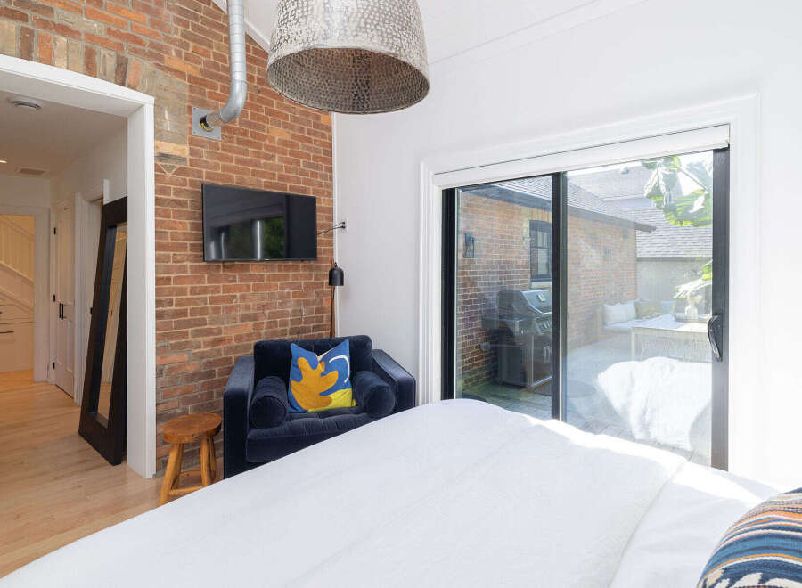 This stunning bedroom boasts a unique brick accent wall, adding character and warmth to the space.