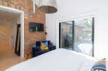 This stunning bedroom boasts a unique brick accent wall, adding character and warmth to the space.