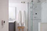 Step into a beautifully designed bathroom featuring a modern glass shower enclosure and elegant marble-look tiles.