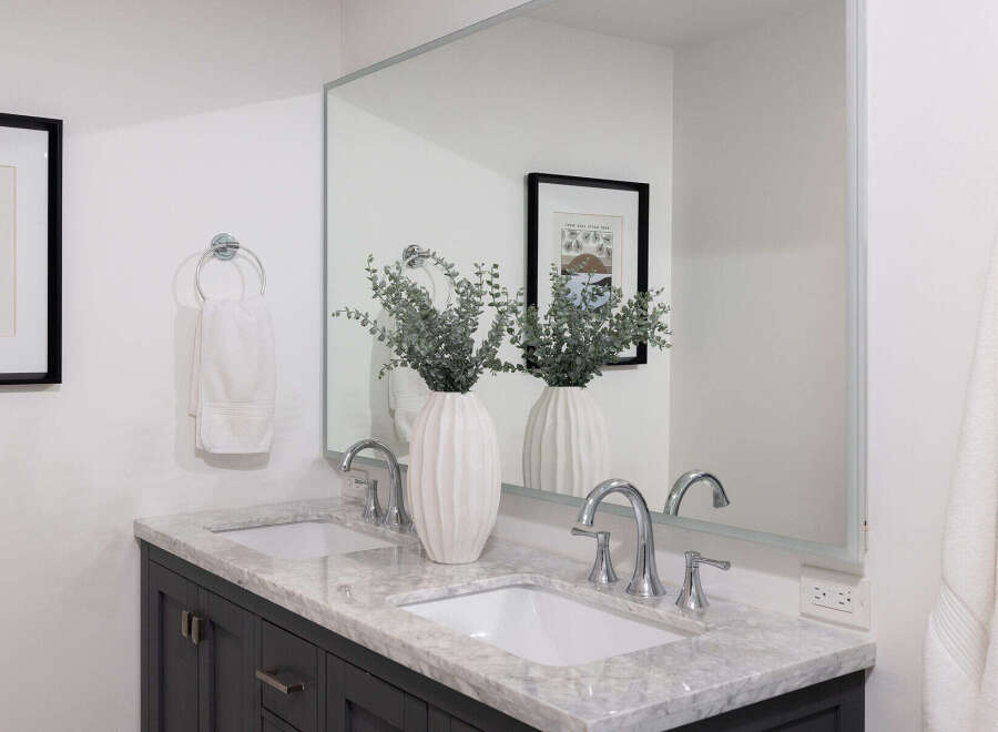 This stunning bathroom features a modern design with a marble countertop and dual sinks, offering both style and functionality.