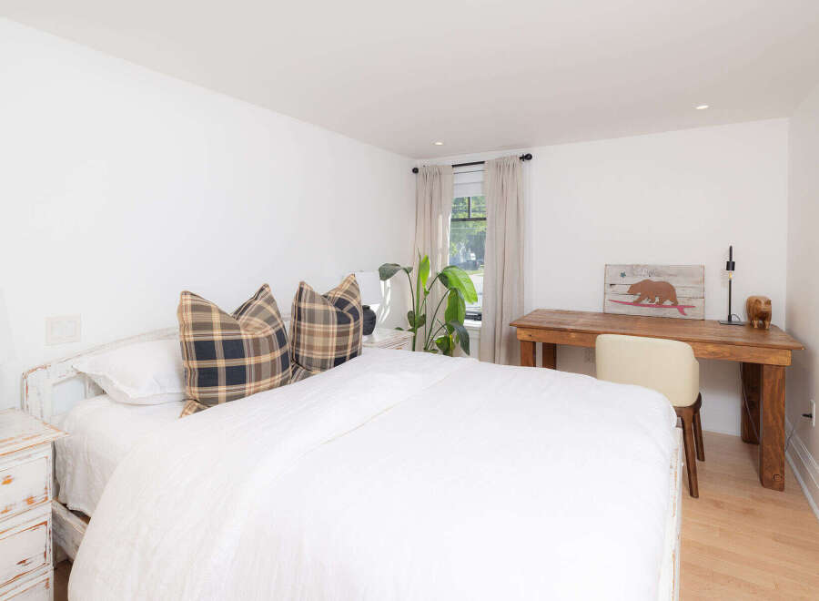 This inviting bedroom boasts a serene atmosphere with its bright white walls and natural light.