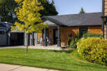 Charming brick home with a welcoming front porch and lush landscaping.