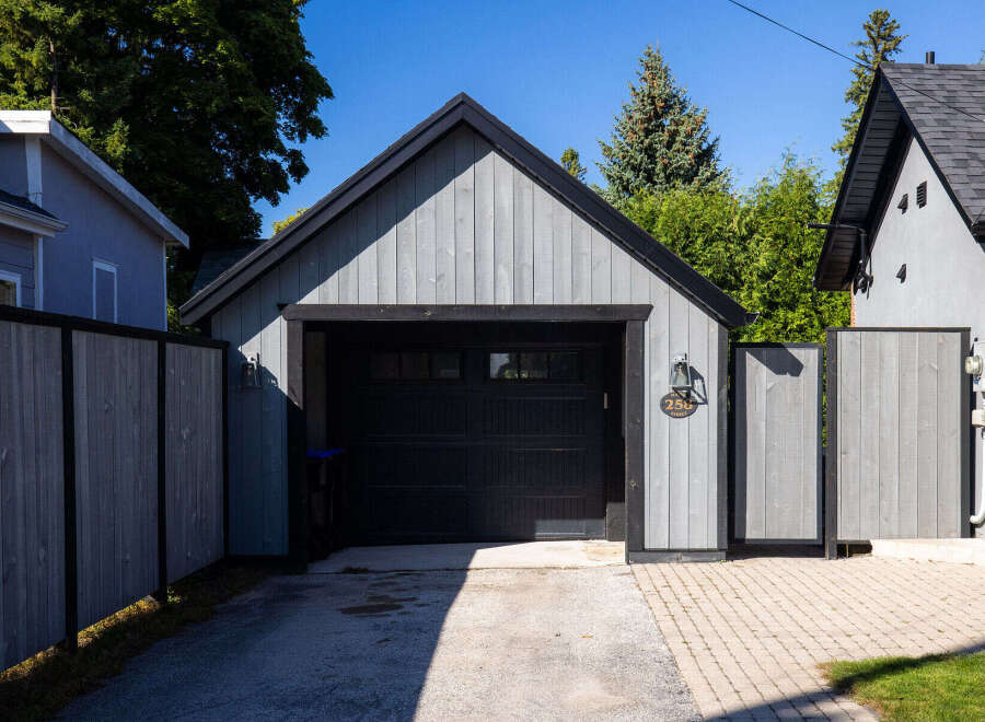 This charming property features a detached garage with a stylish, modern design, perfect for storing vehicles or creating a workshop.