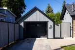 This charming property features a detached garage with a stylish, modern design, perfect for storing vehicles or creating a workshop.