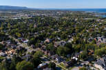 An aerial view showcases a charming residential area, highlighting the lush greenery and well-maintained homes.