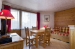 Cozy chalet apartment featuring a wooden interior, comfortable sofa bed, and dining area.