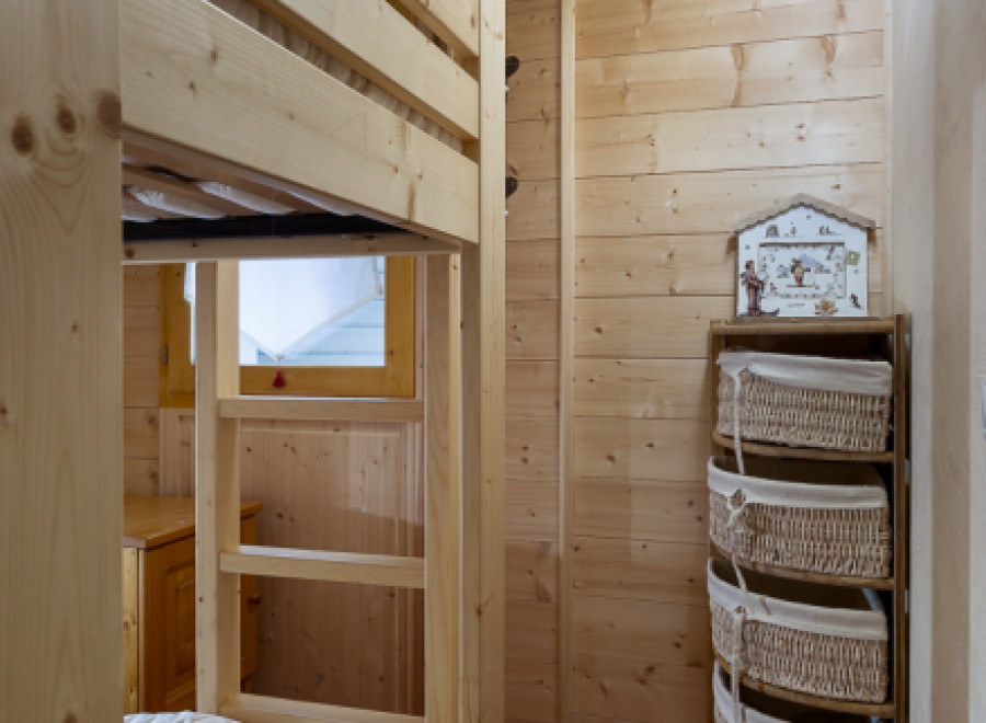 Cozy wooden bunk bed in a charming chalet-style room.
