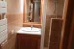 Cozy bathroom with wooden vanity and tiled walls.