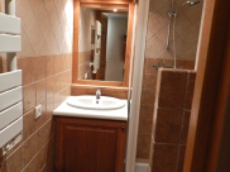 Cozy bathroom with wooden vanity and tiled walls.