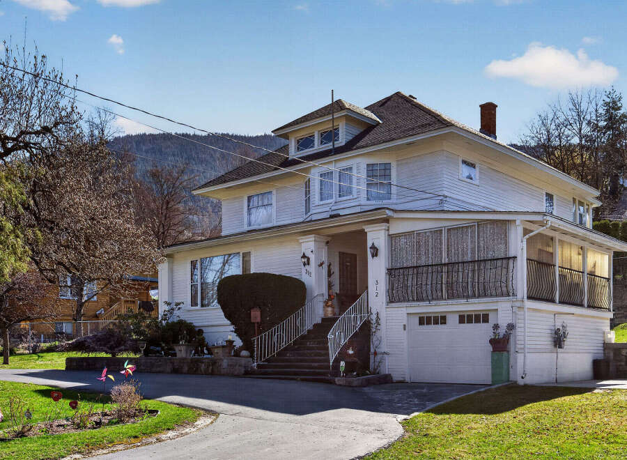 Charming two-story home with a classic design, featuring a welcoming front porch and a well-maintained exterior.