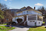 Charming two-story home with a classic design, featuring a welcoming front porch and a well-maintained exterior.