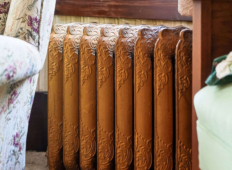 This image showcases a beautifully preserved antique radiator, a charming detail often found in historic homes.
