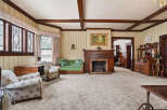Step into this charming living room, featuring a cozy fireplace and elegant wooden accents.
