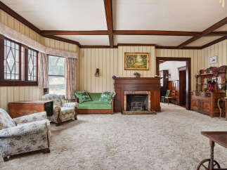 Step into this charming living room, featuring a cozy fireplace and elegant wooden accents.