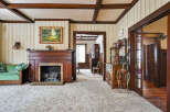 Step back in time with this charming property featuring a cozy living room with a fireplace and plush carpet.