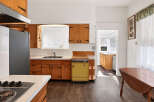 Step into this charming kitchen, featuring classic wooden cabinetry and a unique yellow dishwasher.
