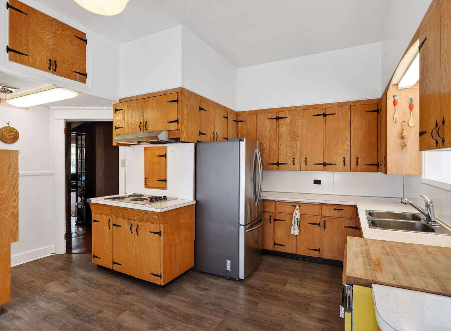 Step into this charming kitchen, featuring classic wooden cabinetry and a functional layout.