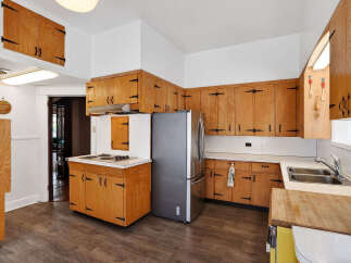 Step into this charming kitchen, featuring classic wooden cabinetry and a functional layout.