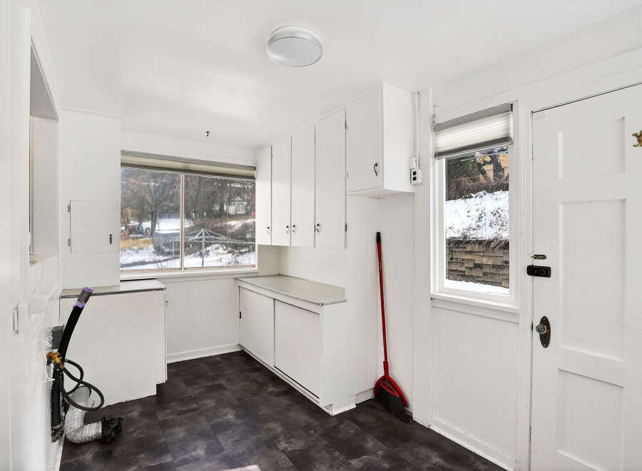 This bright and airy kitchen space offers ample storage with its white cabinetry and countertop.