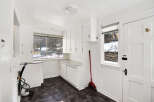 This bright and airy kitchen space offers ample storage with its white cabinetry and countertop.