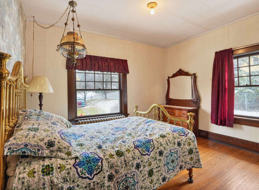 Step into this charming bedroom, featuring a vintage brass bed frame and a cozy, patterned quilt.