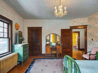 Step back in time with this charming bedroom, featuring original hardwood floors and vintage details.