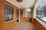 Step into this inviting space with warm wood paneling and a cozy carpet.