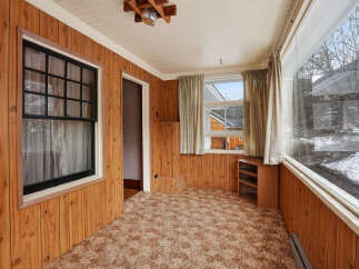 Step into this inviting space with warm wood paneling and a cozy carpet.