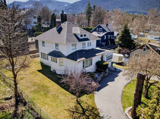 This stunning white house boasts a classic design with a charming porch and a well-maintained lawn.