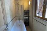 Discover this charming bathroom featuring a cozy bathtub and a convenient showerhead.