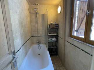 Discover this charming bathroom featuring a cozy bathtub and a convenient showerhead.