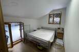This cozy bedroom offers a serene retreat with its bright, airy atmosphere and a comfortable bed.