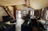 Discover this charming property featuring a cozy living space with a unique wooden ceiling and stone flooring.