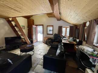 Discover this charming property featuring a cozy living space with a unique wooden ceiling and stone flooring.