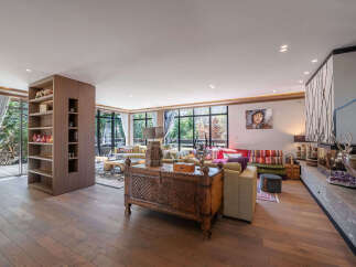 Step into luxury with this stunning living room, featuring exquisite wooden floors and a cozy fireplace.
