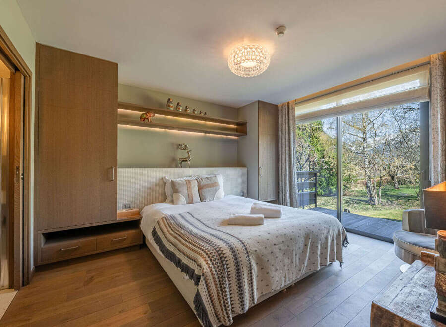 Step into a serene bedroom retreat, featuring a cozy bed adorned with soft linens and a stylish throw blanket.