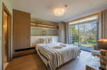 Step into a serene bedroom retreat, featuring a cozy bed adorned with soft linens and a stylish throw blanket.
